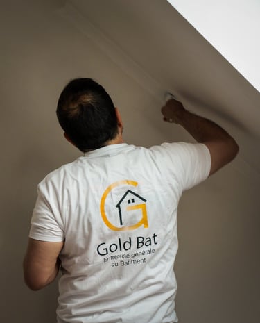 a man in a white shirt is painting a wall