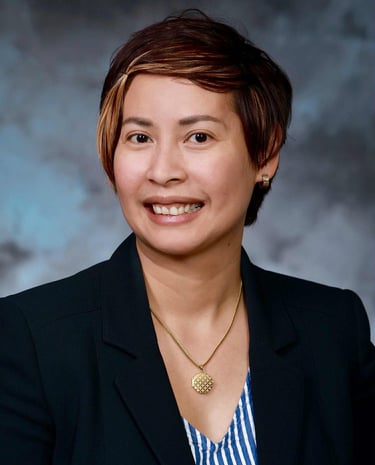 a woman in a black jacket and a blue and white striped shirt