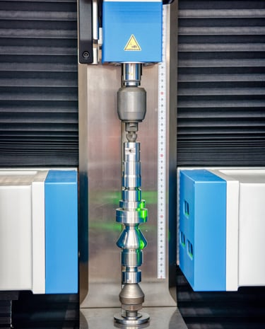 Shaft scanner inspecting a precision shaft using collimated monochromatic light. 