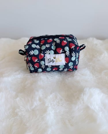 Handmade strawberry print keychain pouch with zipper on white faux fur.