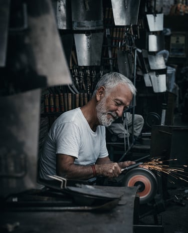 Experienced craftsman sharpening a blade in a workshop with focus and precision
