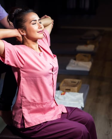 a woman in a pink shirt is sitting on a chair