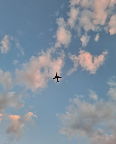a plane flying through the sky with clouds
