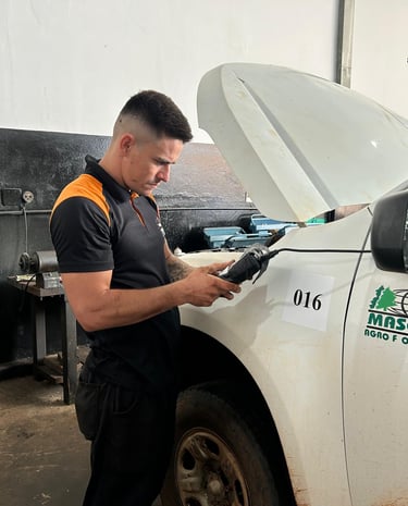 Imagem de um mecânico com o scanner eletrônico, buscando erros e falhas do veículo