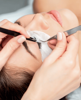 a woman is getting her eyebrows done by a professional makeup artist