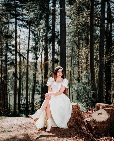 Bride sitting gracefully among tall forest trees in Surrey, photographed by Fred Art Studio.
