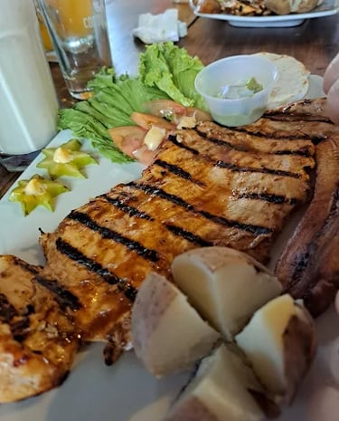 Plato típico colombiano servido en Parrilla y Vinos Juan Esteban, con carne asada al carbón, papas