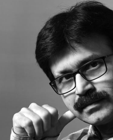 A close-up of a mane wearing specs and muoustache.