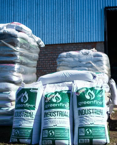 una pila de bolsas de sustrato frente a un galpón