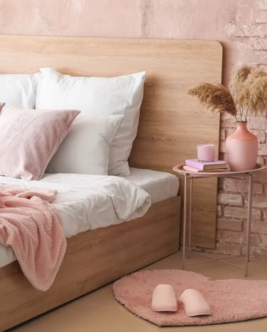 Chambre à l'ambiance apaisante avec lit en bois clair, parure de lit blanc et murs roses