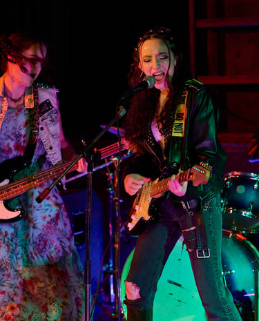 Actress Sofia Skates, Sophia Chapdelaine and Tristan Miura play music in a scene of Lupe Q Corn Cake