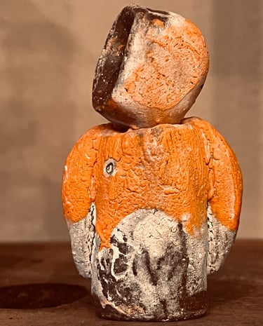Handcrafted rustic ceramic figurine with a textured orange and black glaze finish.