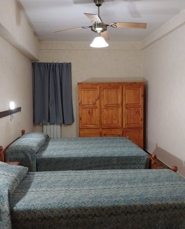 Una habitación con una cama matrimonial y otra cama individual