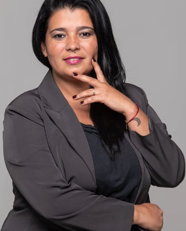 a woman in a gray suit and a red bracelet