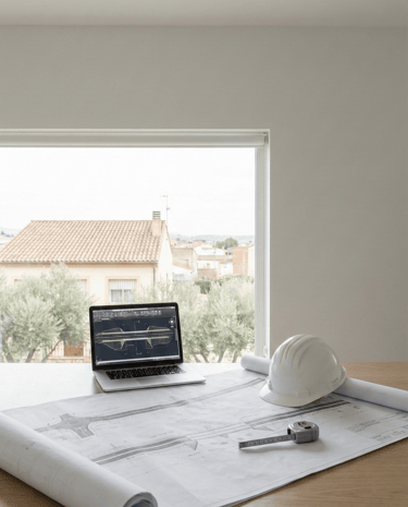 Planos de ingeniería civil y equipo técnico en oficina para planificación de obra en Sevilla.