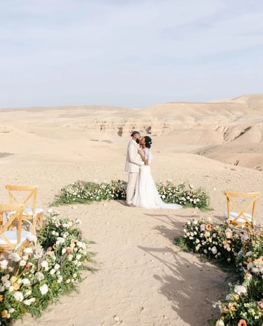 a couple standing in a desert with a desert backdrop