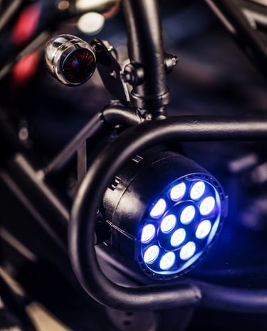 A round blue LED stage light mounted on a black metal rigging frame for professional event lighting.