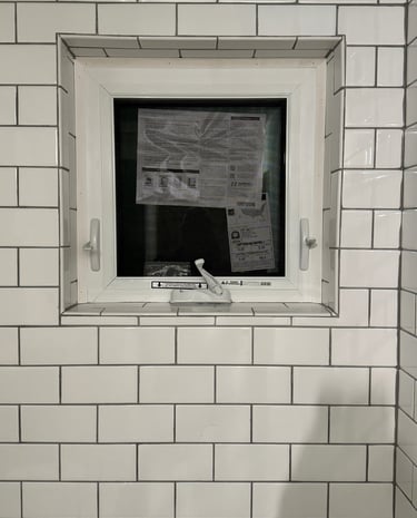 a bathroom window with a window in the middle of it