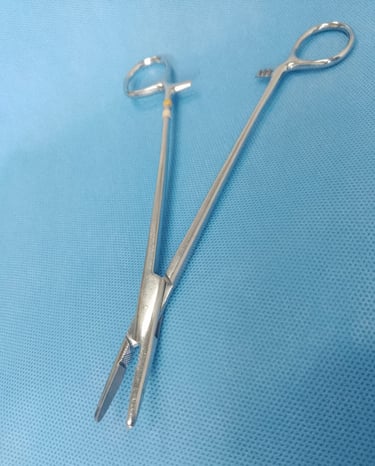 Porta-agulha cirúrgico sobre tecido azul estéril, usado para sutura.