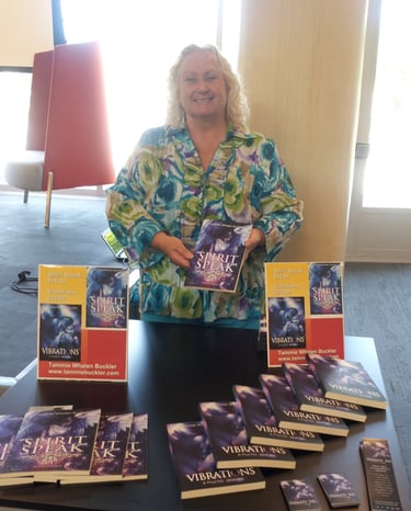 a woman standing in front of a table with booksks and a book