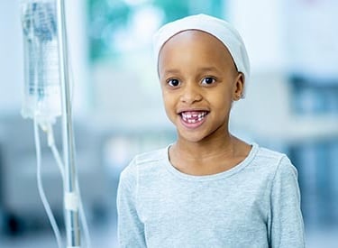 Image d'un enfant atteint de cancer qui a le sourire