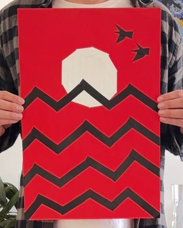 papel vermelho, onde um sol branco está desenhado com fitas, que também fazem o desenho de ondas pretas e duas aves no céu.