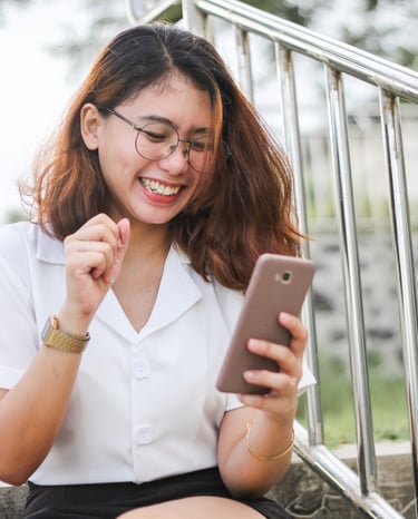 a woman sitting on a stair case holding a cell phone