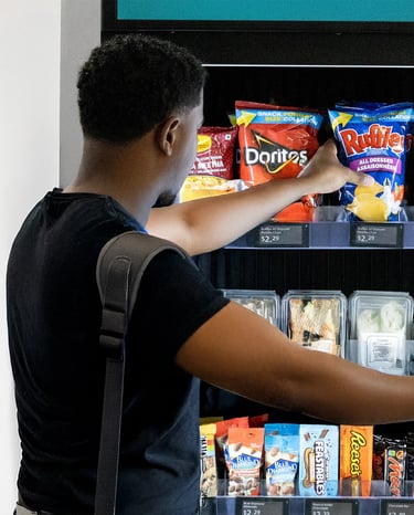 a man grabbing snacks from a vending machine