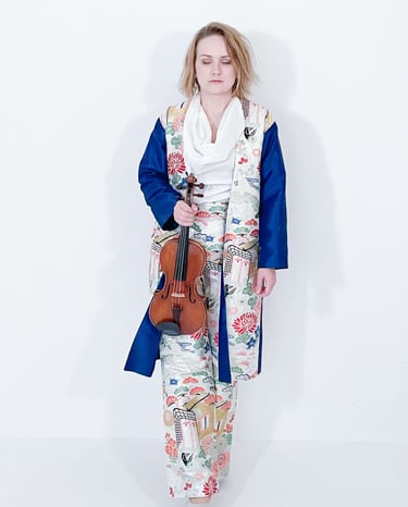Portrait of Žydrė in traditional Japanese-inspired dress, eyes closed in contemplation while holding violin