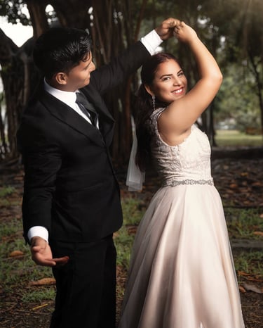 a man and woman in formal wear standing in a park