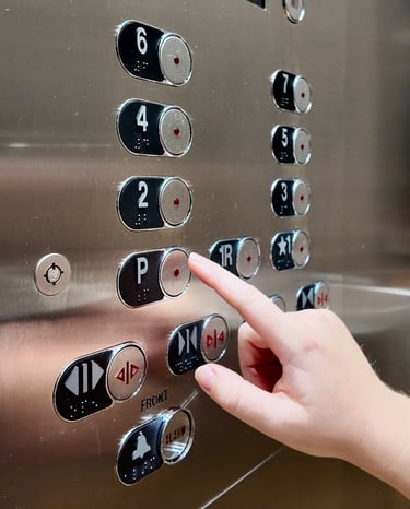a hand with finger stretching out to puch the floor button inside an elevator