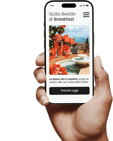 Mano che tiene uno smartphone che mostra la homepage di un B&B siciliano, con foto di un giardino