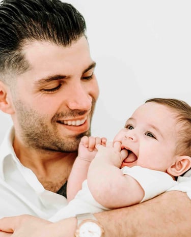 Father smiling while holding baby – Fred Art Studio family session