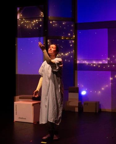 A white person in hospital gown raising her arm towards the ceiling. Behind her, stars dance.