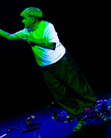 A white person bathed in green light, reaching up towards... something