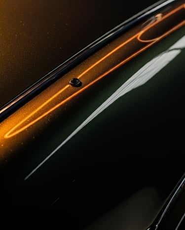 imagem aproximada de parte da lataria de um automóvel de cor escura, demonstrando seu brilho.
