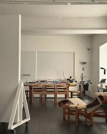 Minimal studio interior with a chaise longue, wooden table and calm modern furniture inspired by Cha