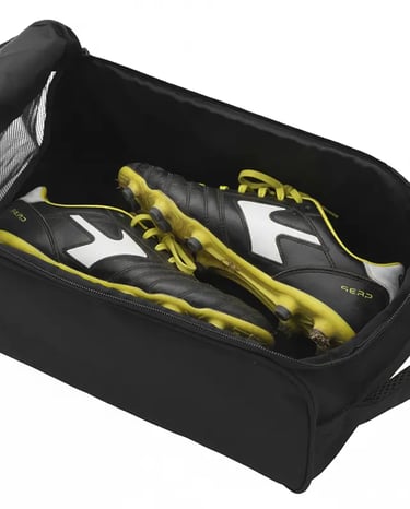 Black and yellow soccer cleats stored inside a durable black athletic shoe bag with zipper closure.
