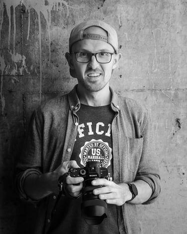 Vincent Dumont tiens une caméra. La photo est noir & blanc