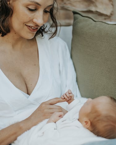 mom looking down at baby in a lifestyle newborn shoot