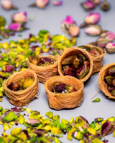 Traditional Middle Eastern pistachio bird nest baklava with crushed nuts and rose buds.