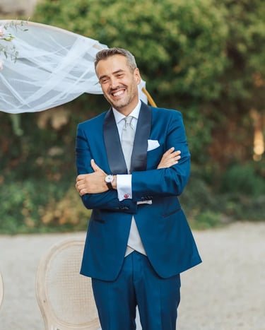 Marié ému et souriant pendant la découverte de sa future épouse, devant une arche fleurie.