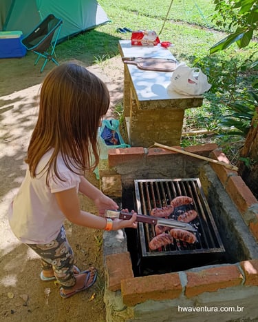 Criança, ajudando no preparo de um churrasco no acampamento