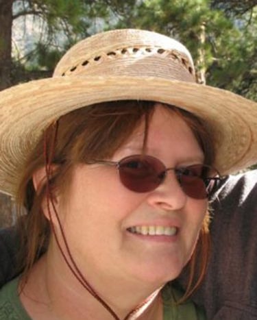 smiling woman in sunglasses and straw hat
