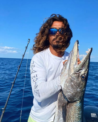 a man with a beard and sunglasses holding a fish