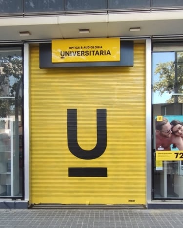 Graffiti en persiana, cierre metálico de Óptica Universitaria, Barcelona