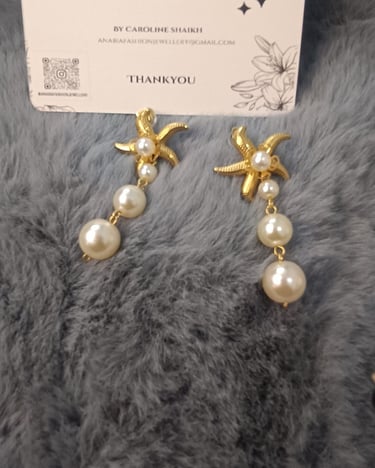 a pair of earrings with pearls and pearls