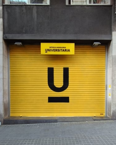 Graffiti en persiana, cierre metálico de Óptica Universitaria, Barcelona