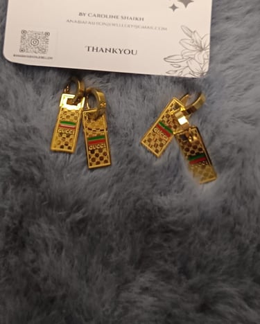 a pair of earrings with gold and silver