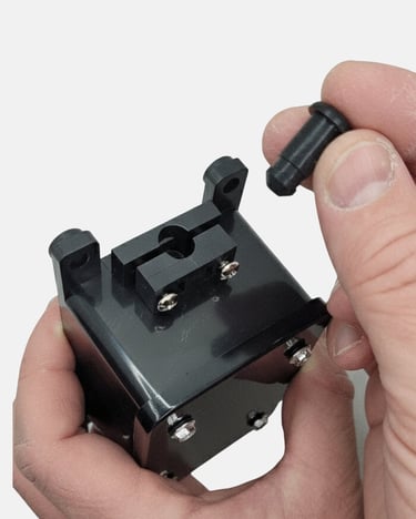 Hand inserting a black plastic mounting pin into a compact industrial electronic housing component.